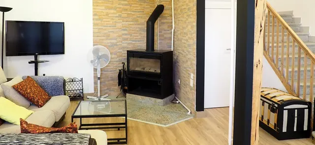 Salón con estufa de leña y televisión